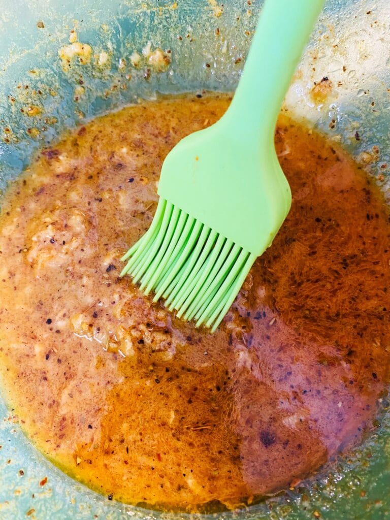 brushing extra sauce from the bowl