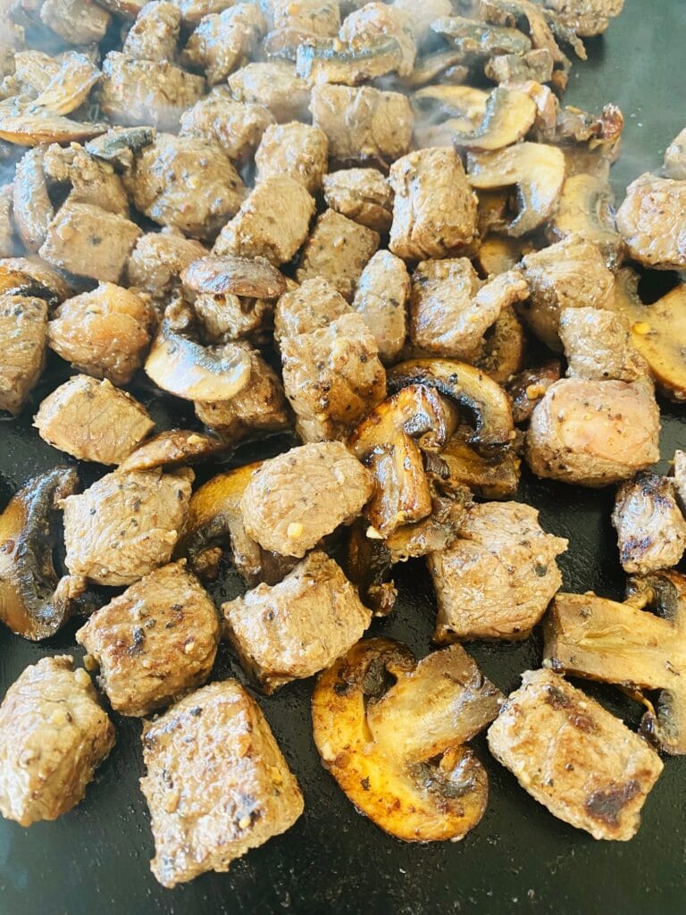 steak bites and mushrooms on the griddle
