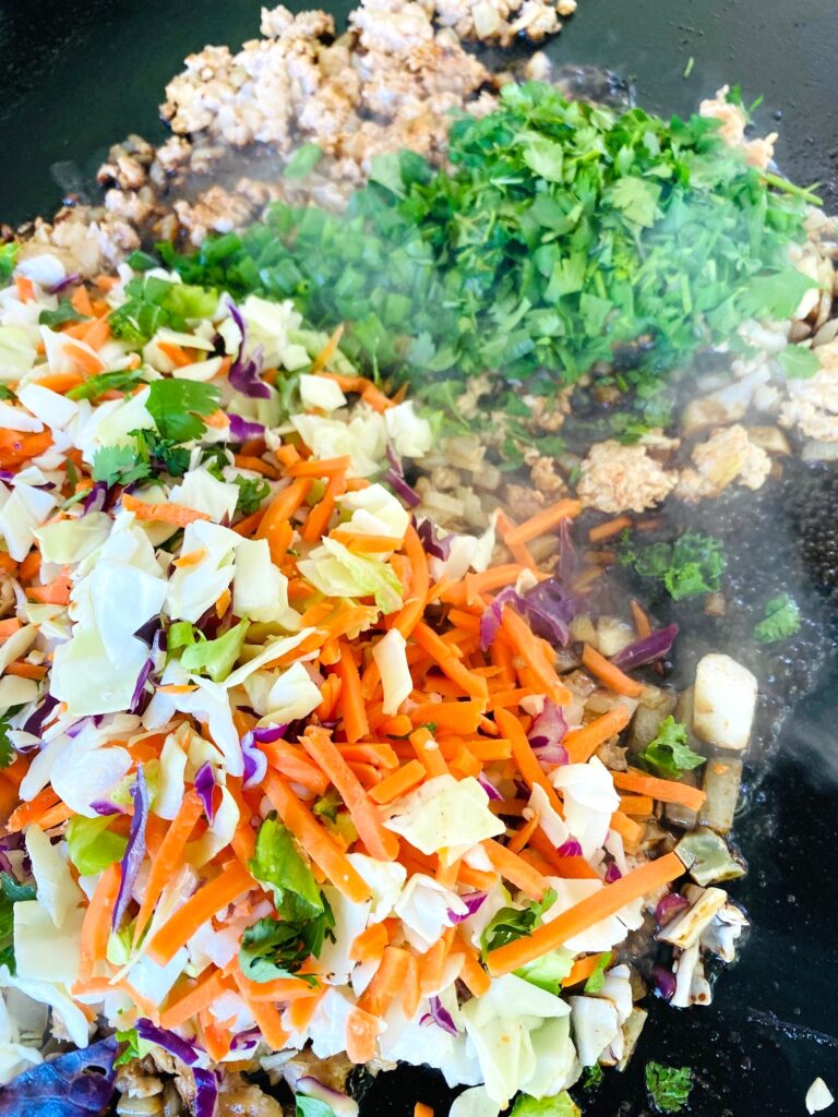adding slaw and seasoning to the griddle