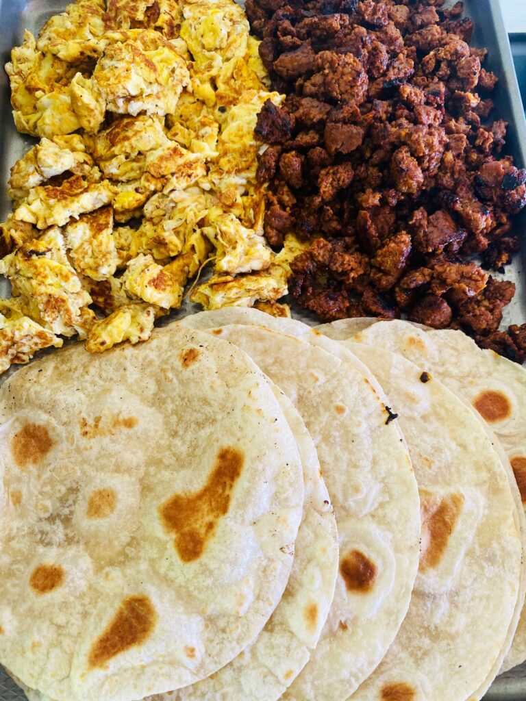 tortillas eggs and sausage on a tray