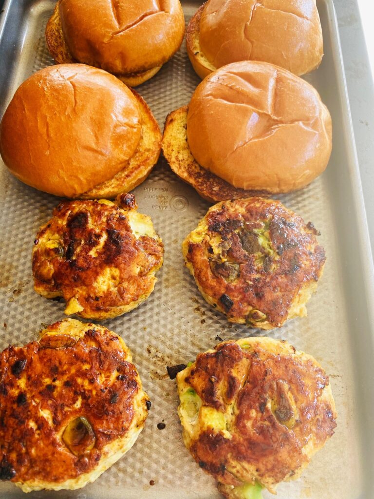 burgers and toasted buns on a tray
