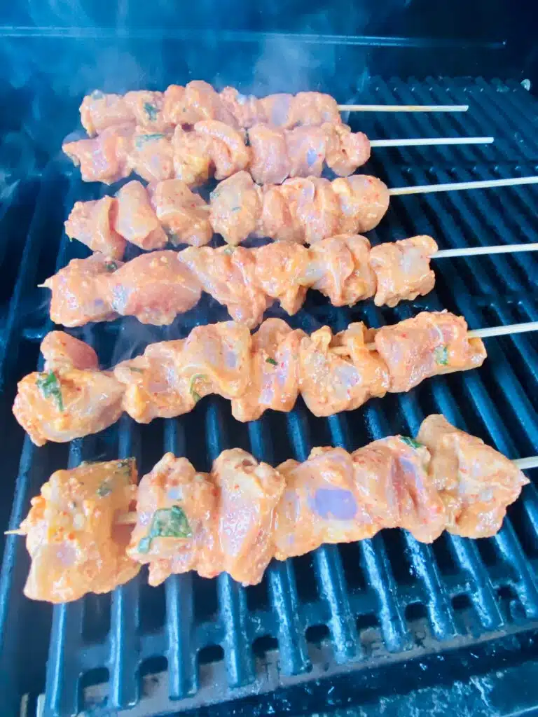 chicken skewers on the grill before cooking