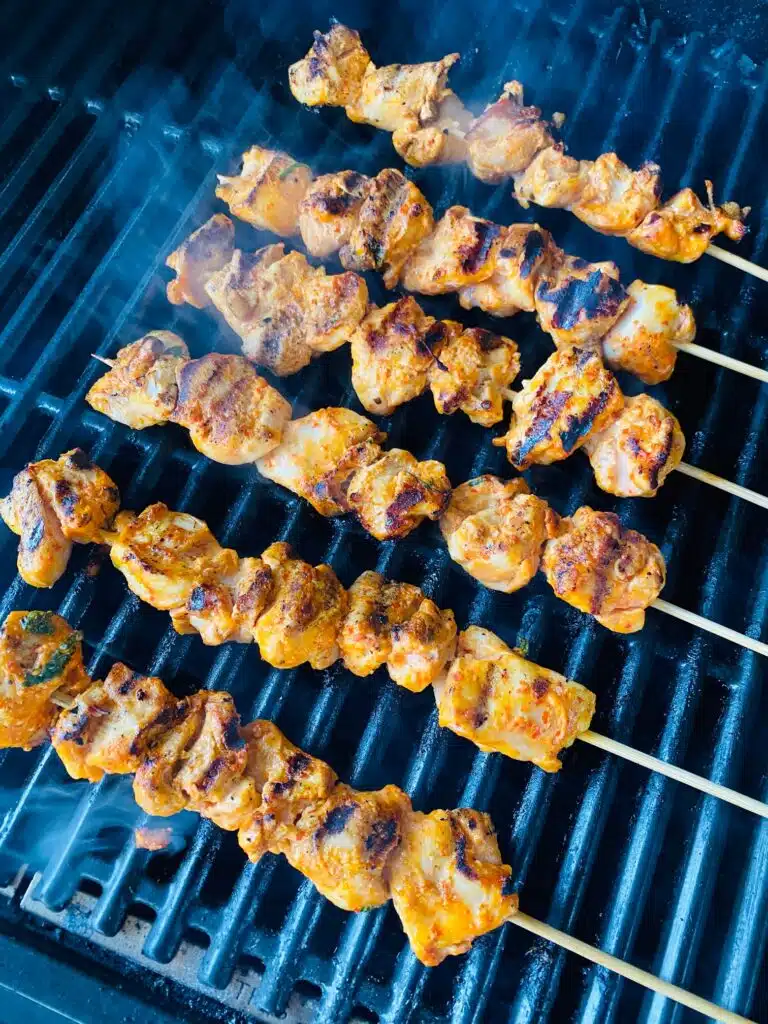 chicken skewers cooking on the grill
