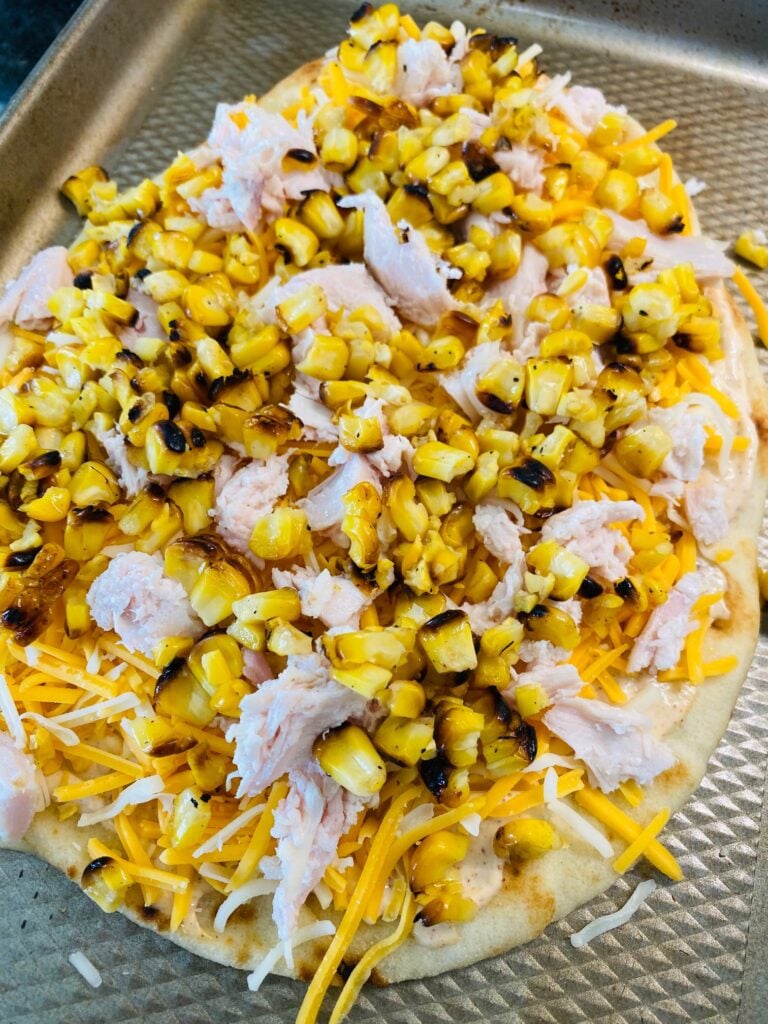 adding corn to the pizza