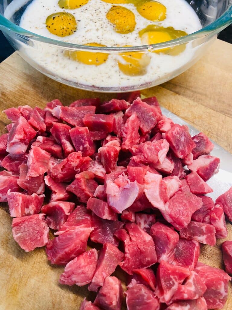 chopping the steak and cracking the eggs in a bowl
