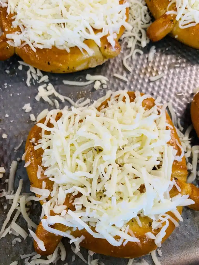 topping the soft pretzels with cheese