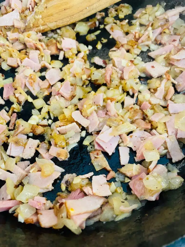 adding diced ham to the skillet