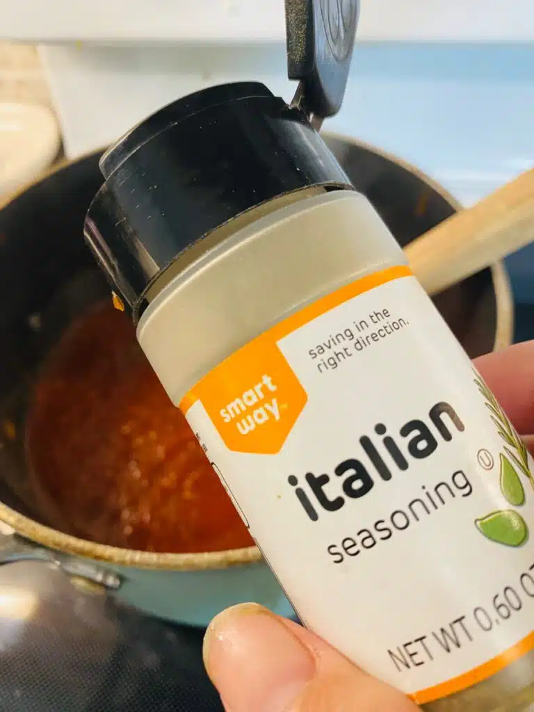 adding Italian seasoning to the sauce