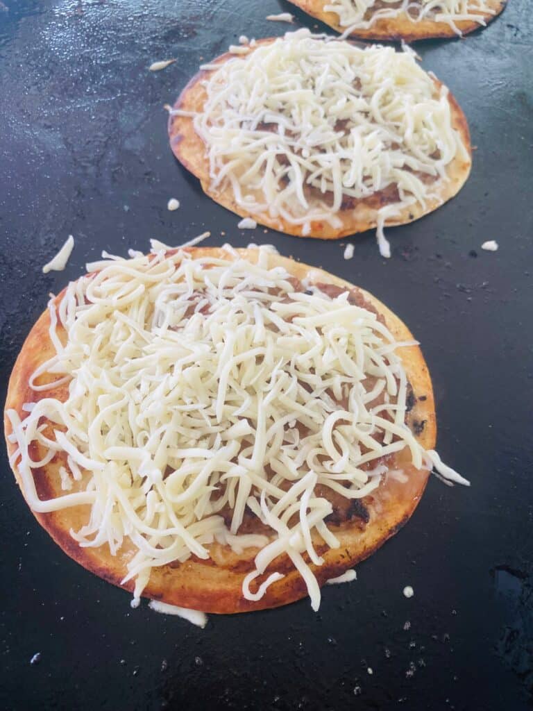 adding cheese to each taco