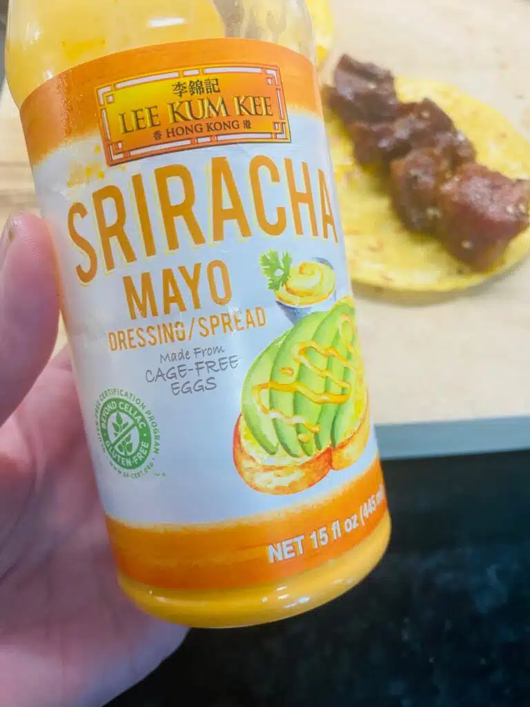 adding spicy mayo to the tacos