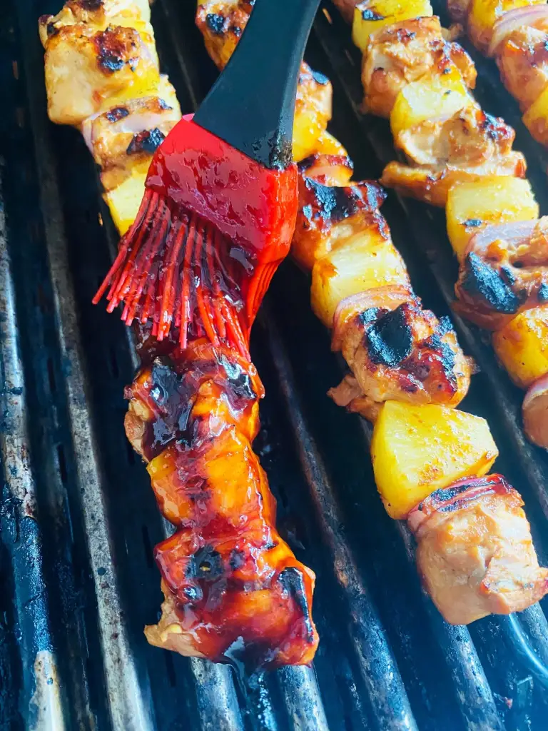 brushing the Grilled Hawaiian BBQ Chicken Skewers with sauce