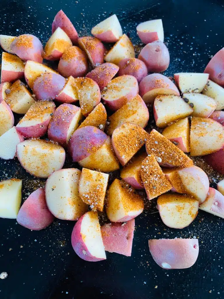 seasoned potatoes on the griddle before cooking
