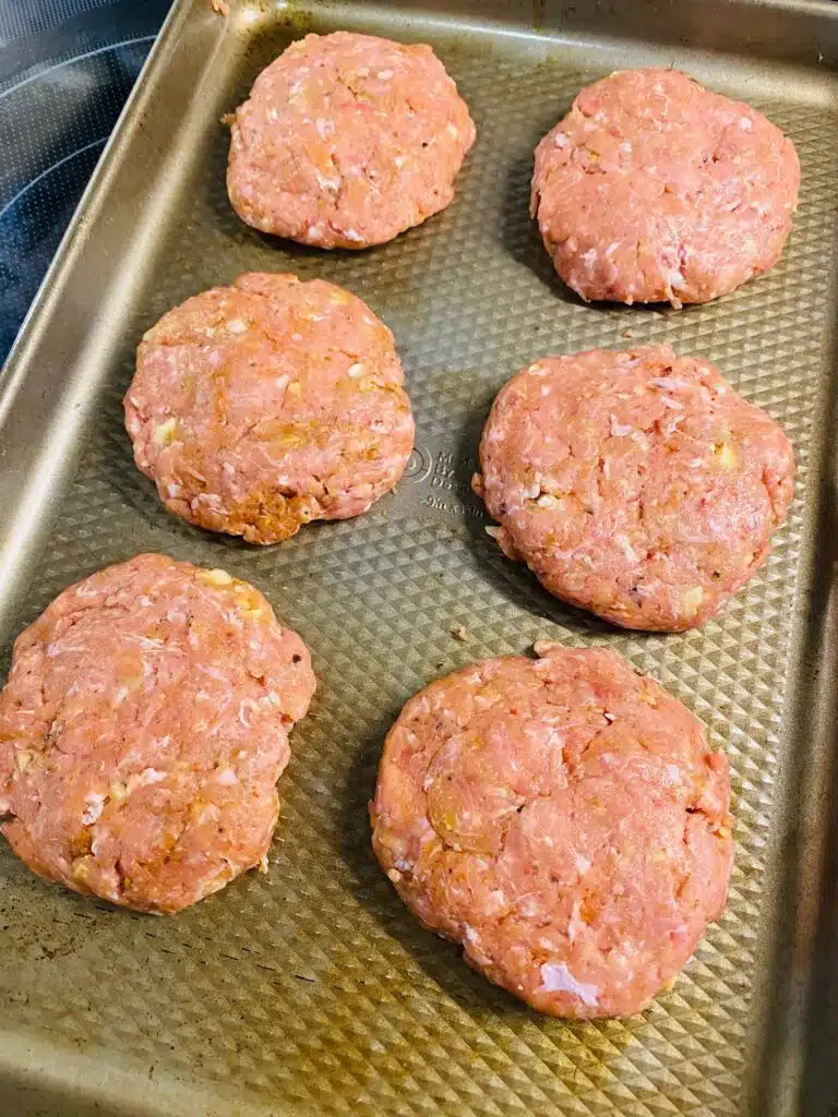 burger patties on a tray before cooking