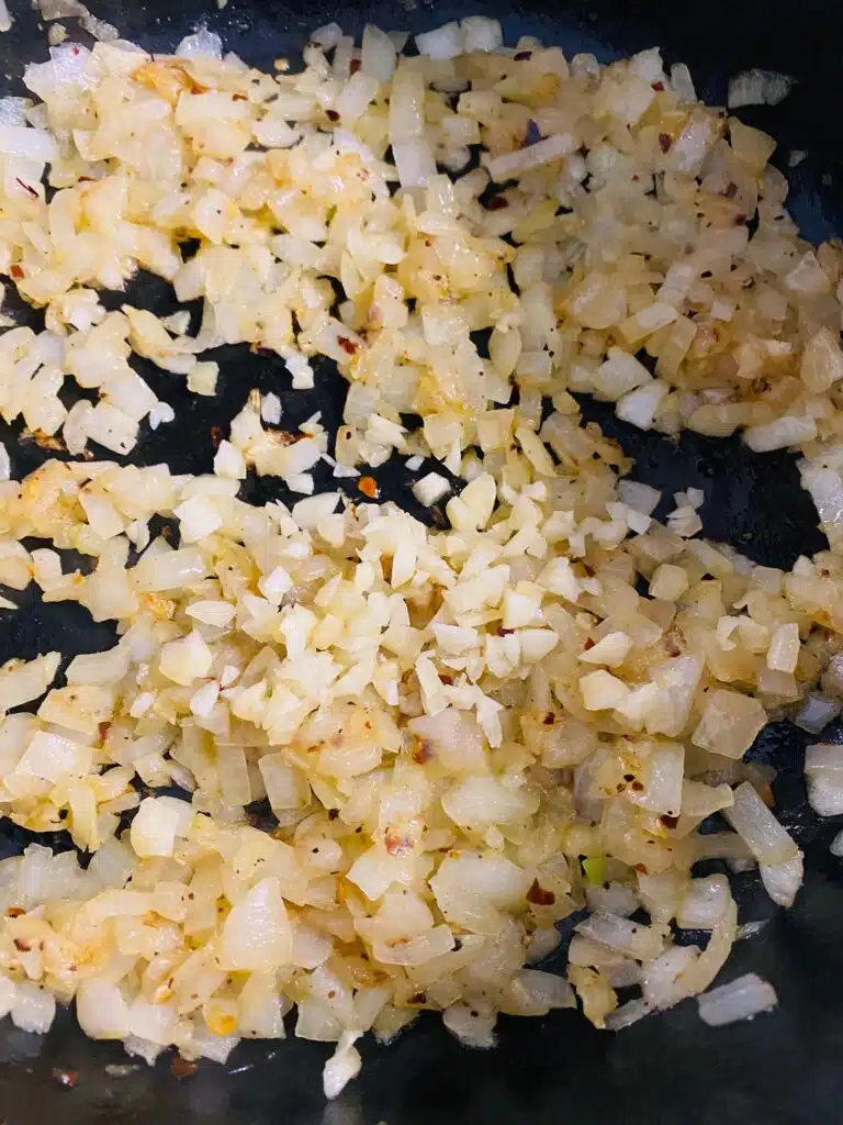 adding garlic to the cooked onions