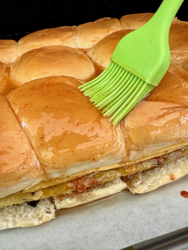 brushing maple butter on Smoked Maple Sausage Breakfast Sliders