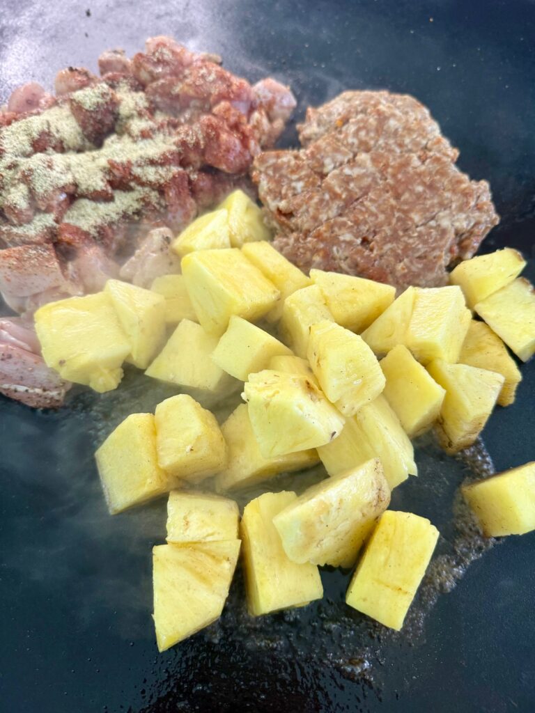 adding pineapple and chorizo to griddle