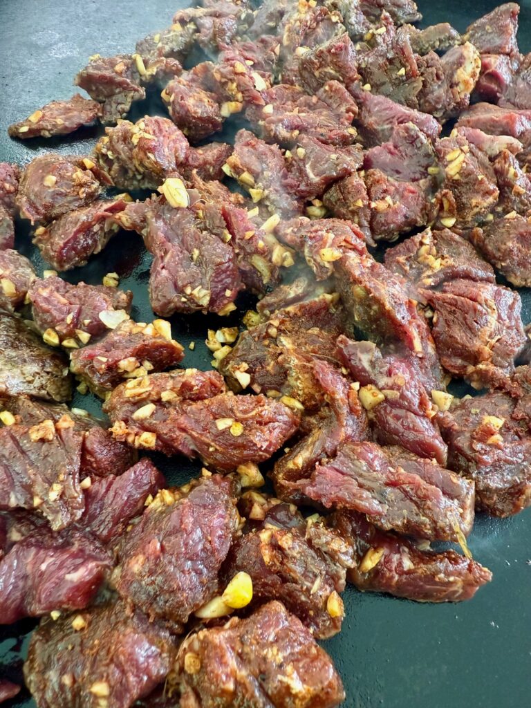 steak cooking on the griddle
