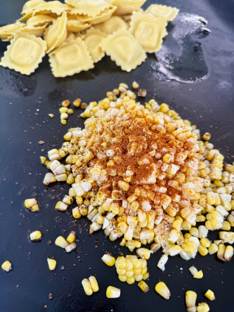 corn and ravioli on the griddle before cooking