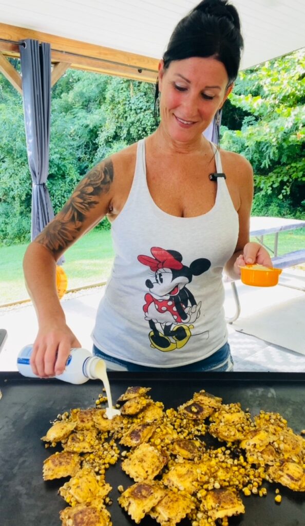 adding cream to Blackstone Crab and Corn Ravioli