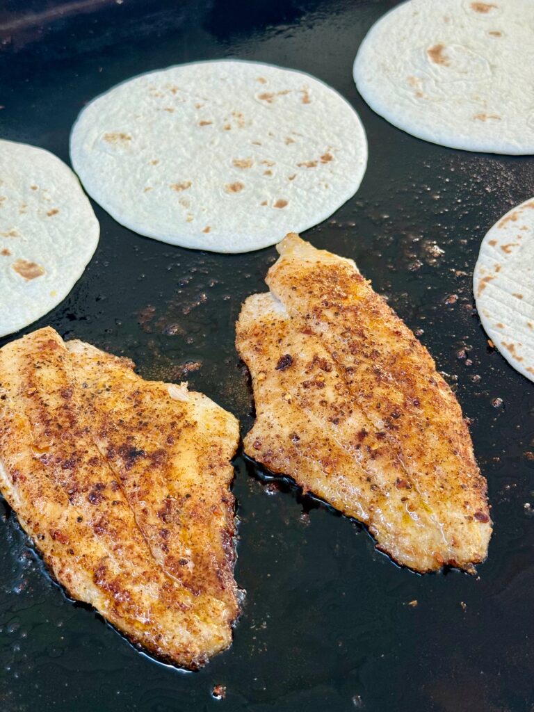 adding tortillas to griddle