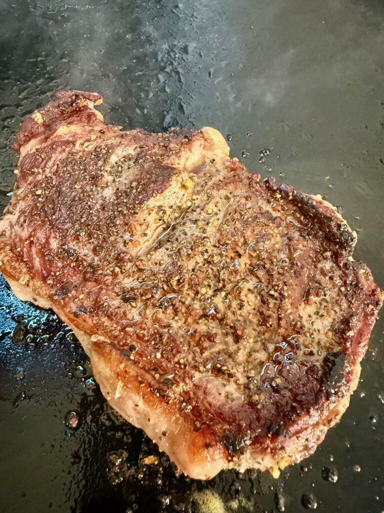 steak cooking on griddle