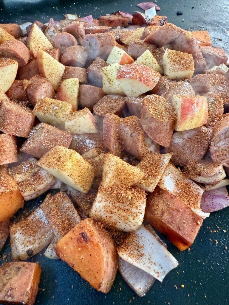 adding apples and sausage to the griddle