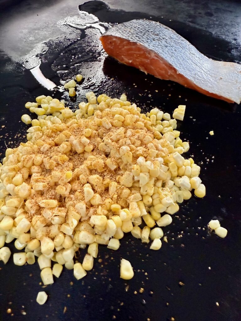 corn and salmon on griddle before cooking