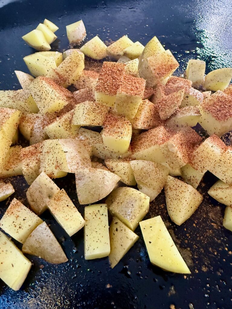adding potatoes to griddle