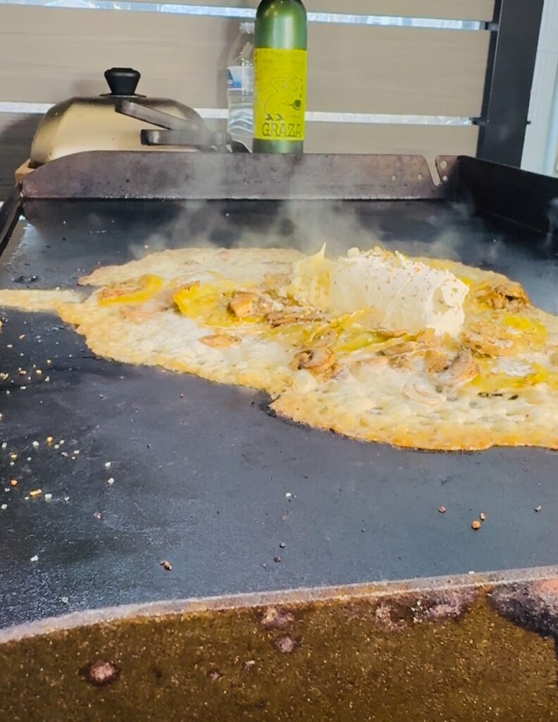 adding cream and goat cheese to Blackstone Goat Cheese Mushroom Ravioli