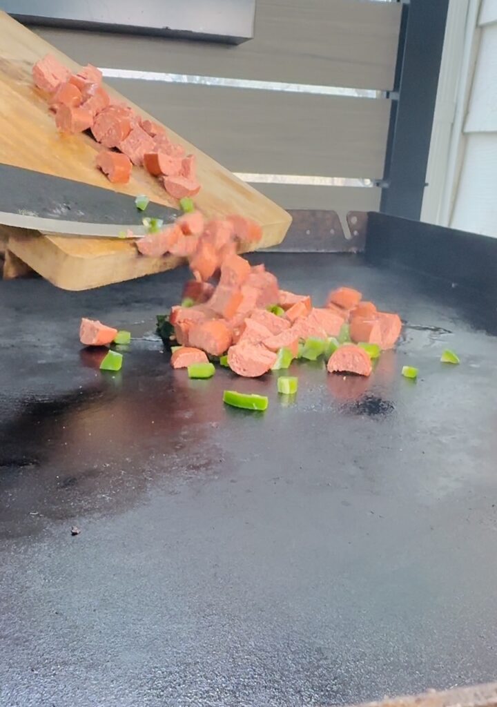 adding sausage and jalapeno to griddle
