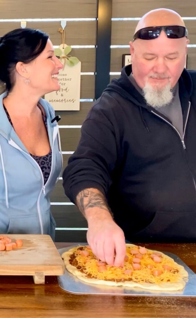 adding cheese and hot dogs