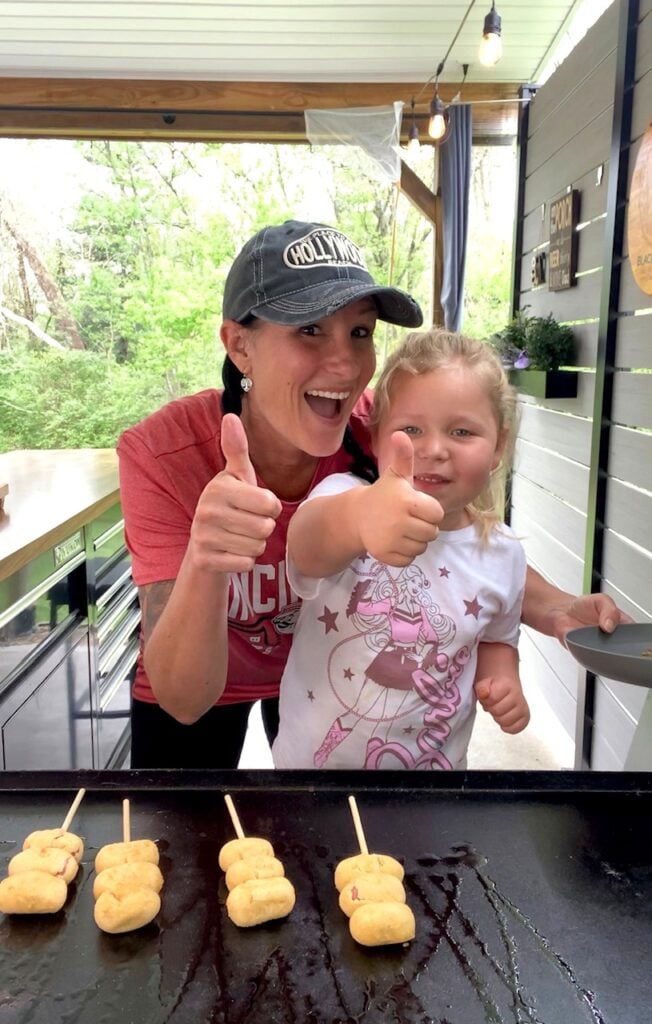 adding the corn dogs to the griddle
