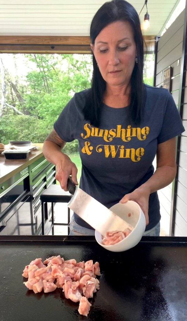 adding chicken to the griddle