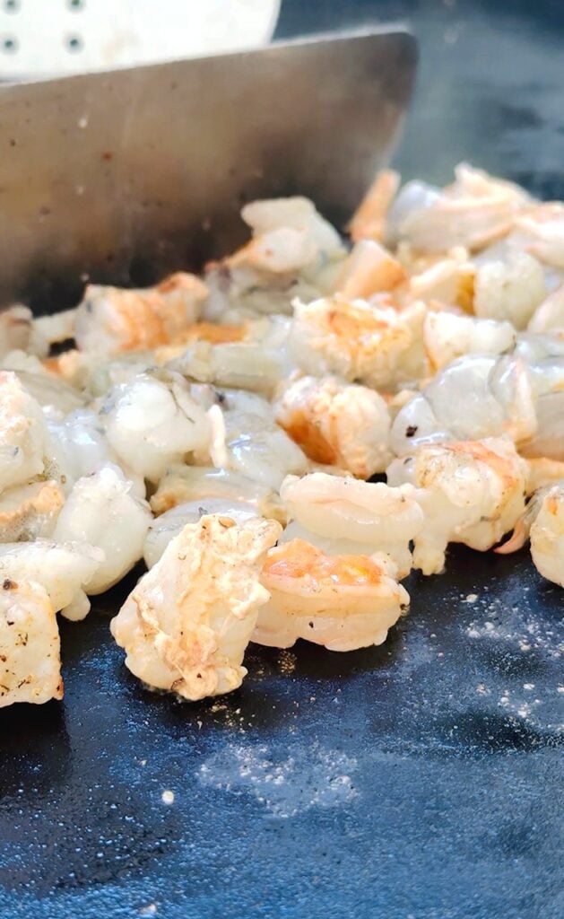 adding shrimp to the griddle