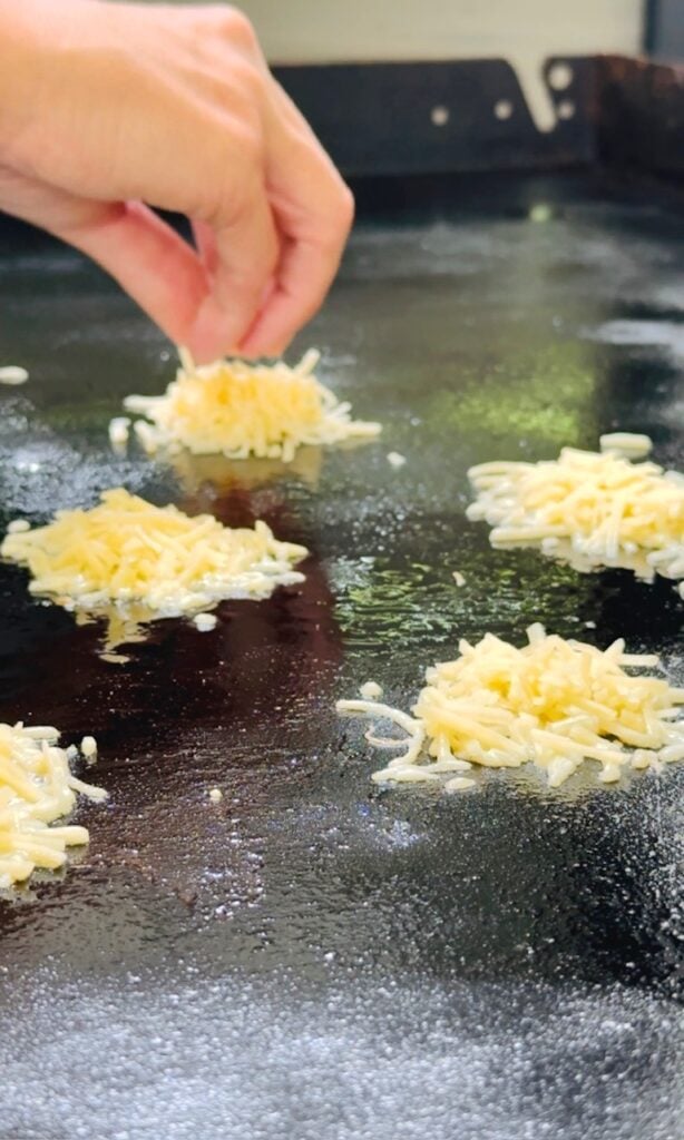 adding piles of cheese to the griddle
