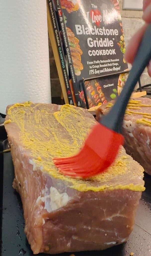 brushing mustard on the chuck roast