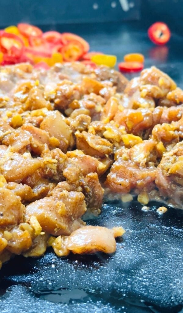 cooking chicken and peppers on the griddle