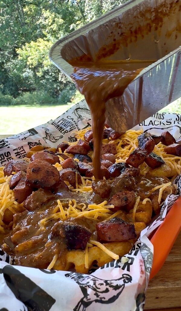 pouring chili over fries